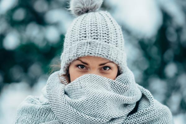 年轻女子穿围巾戴帽 寒冷冬日雪